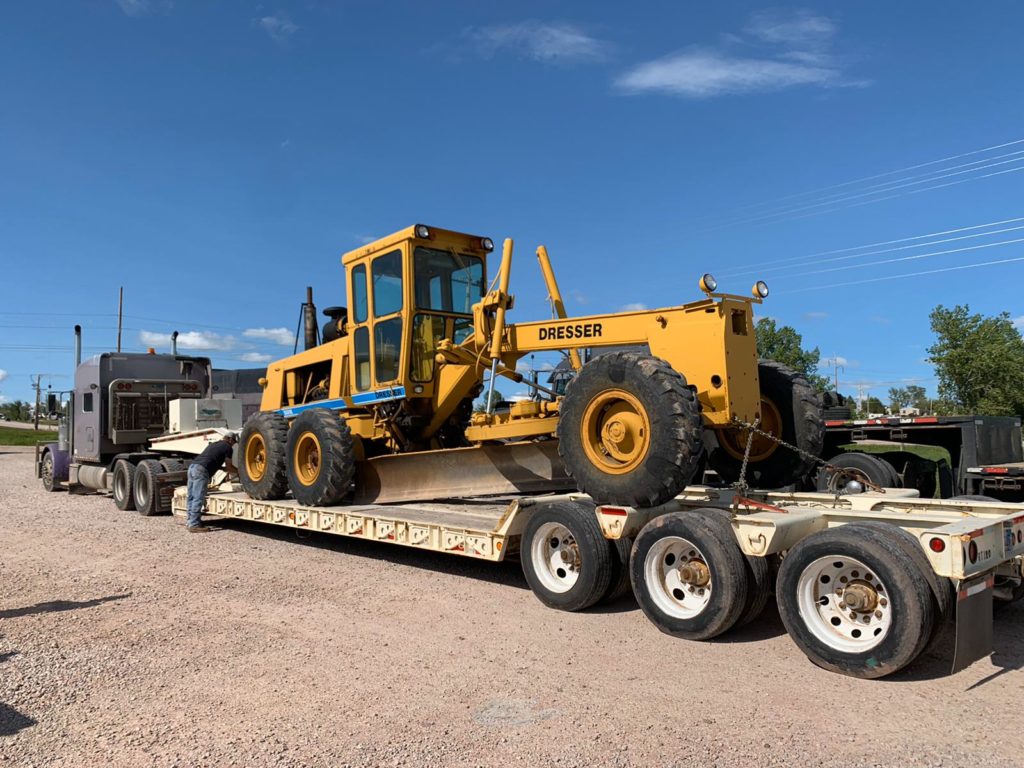 A yellow tractor is on the trailer