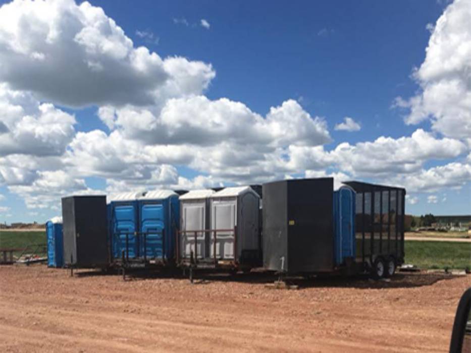 A trailer with many different colored containers on it.