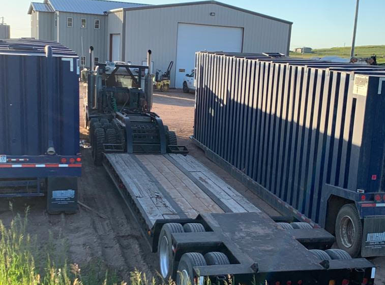 A truck with two large trailers parked in front of it.