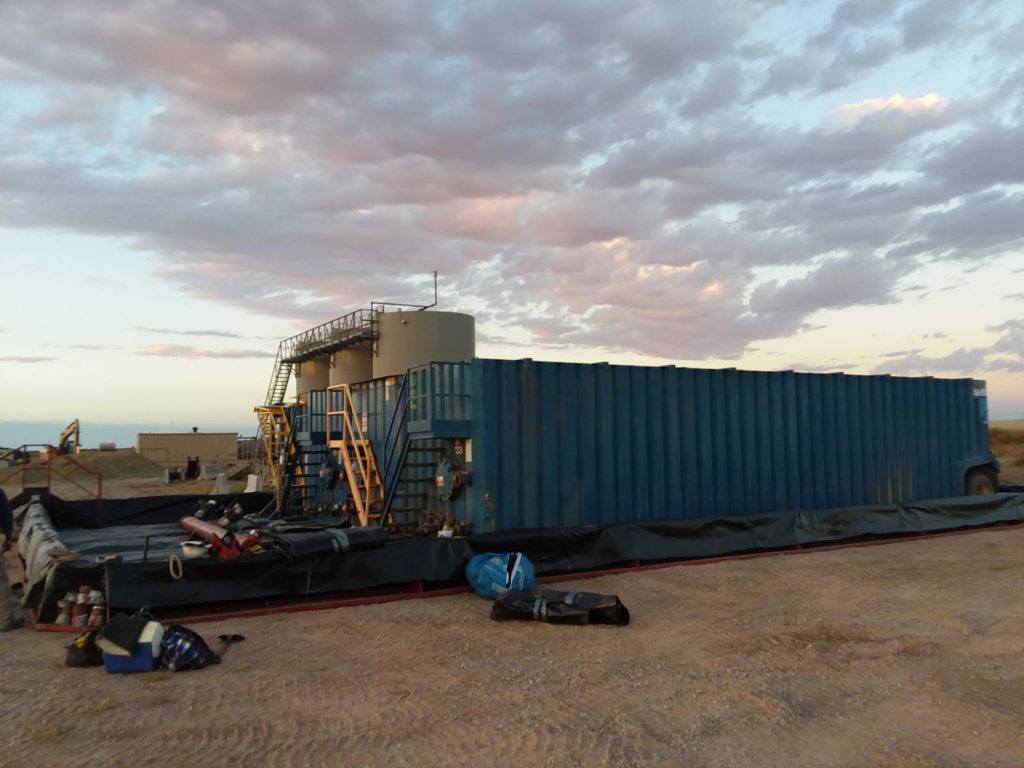 A large blue container truck parked in the desert.