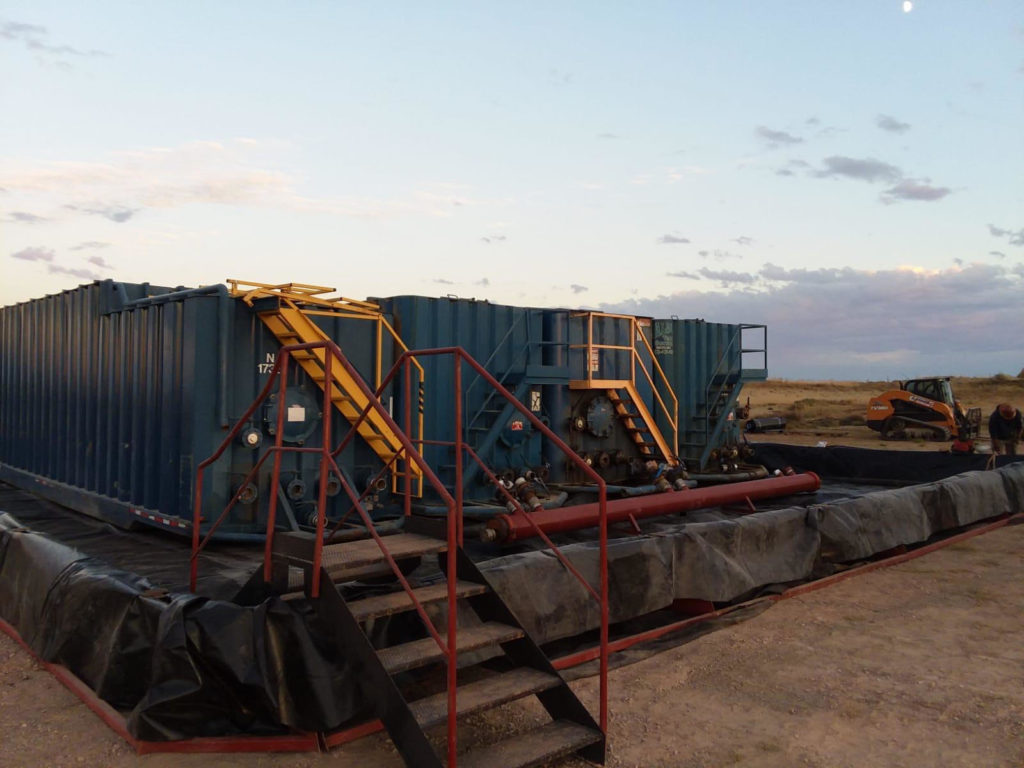 A large blue container sitting next to some stairs.