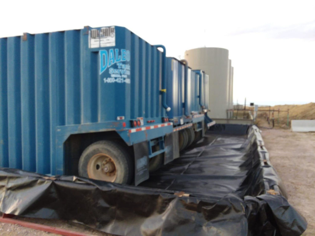 A blue truck parked on top of a road.