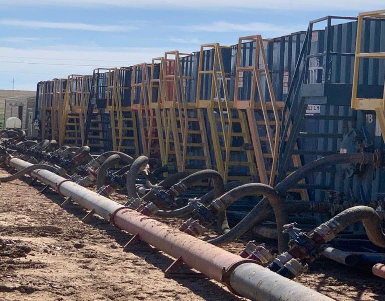 A long line of metal pipes sitting on top of the ground.