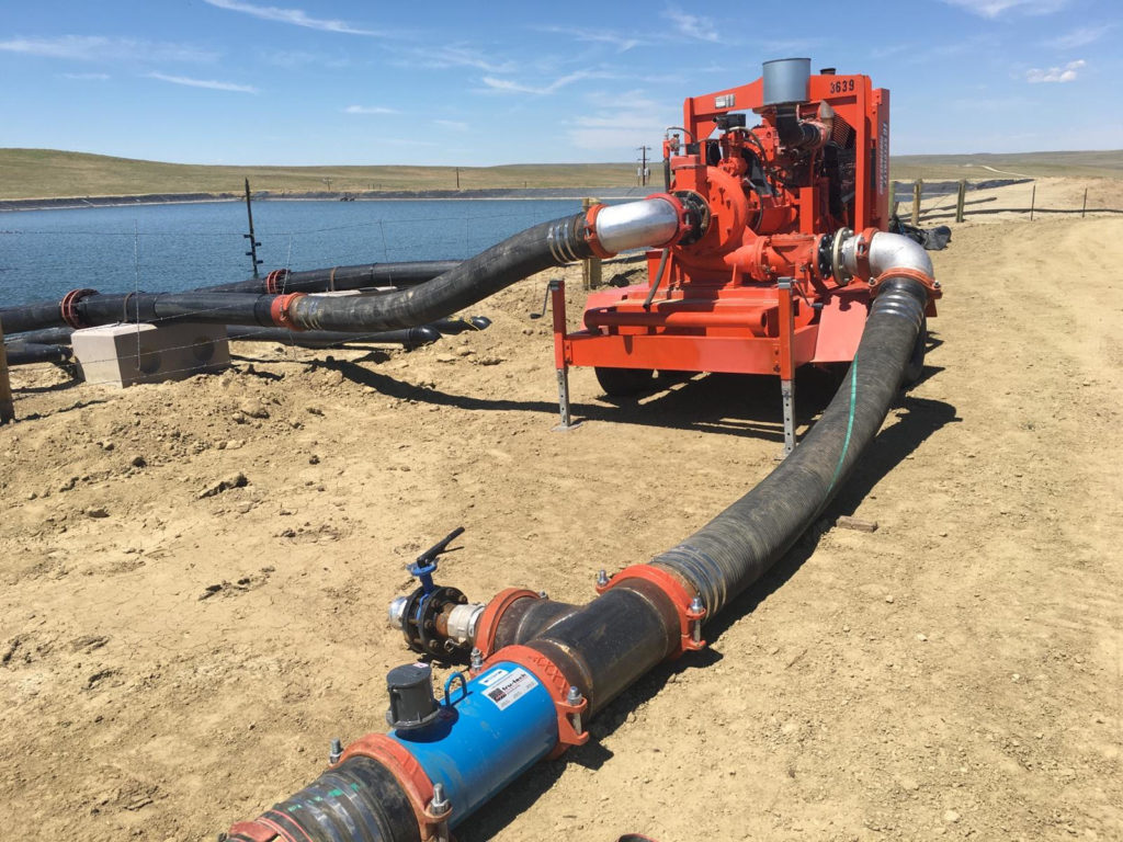 A large pipe laying on top of sand.