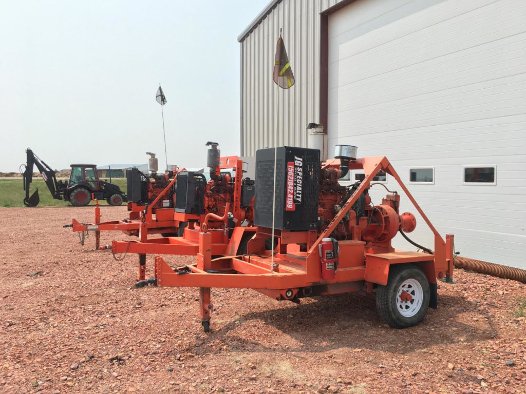 A group of small orange generators sitting in front of a building.